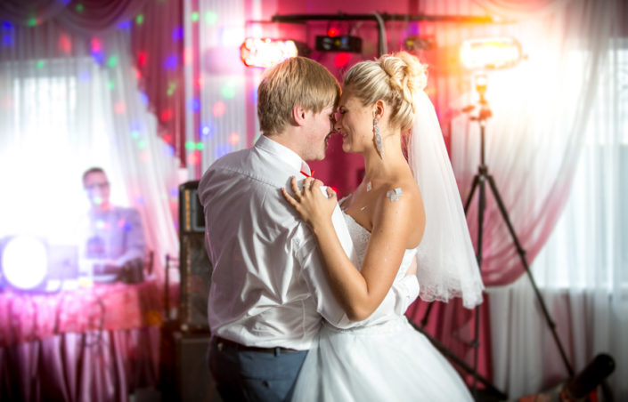 newly married couple dancing at colorful lights and flares